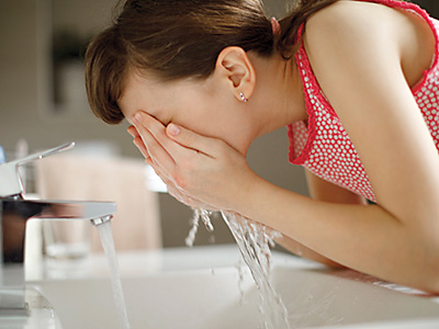 Young girl splashing water on her face