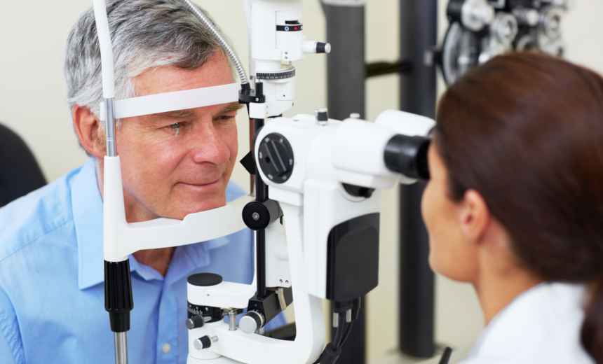 An ophthalmologist examining her patient's eyes with the help of a slit lamp