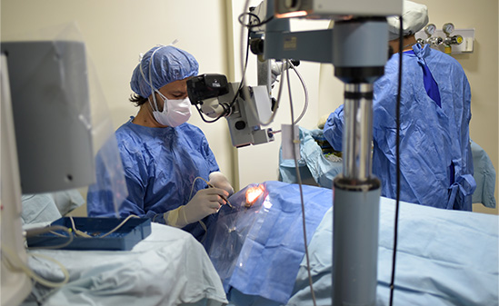 An image of a surgeon performing manual eye surgery on a patient.