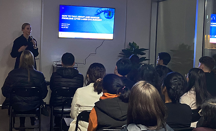 A/Prof Abi Tenen speaks to a group of optometrists at Vision Eye Institute's Melbourne clinic. The projector screen shows a Powerpoint slide bearing the title of her talk, 'How to talk about and manage problems after laser eye surgery.'