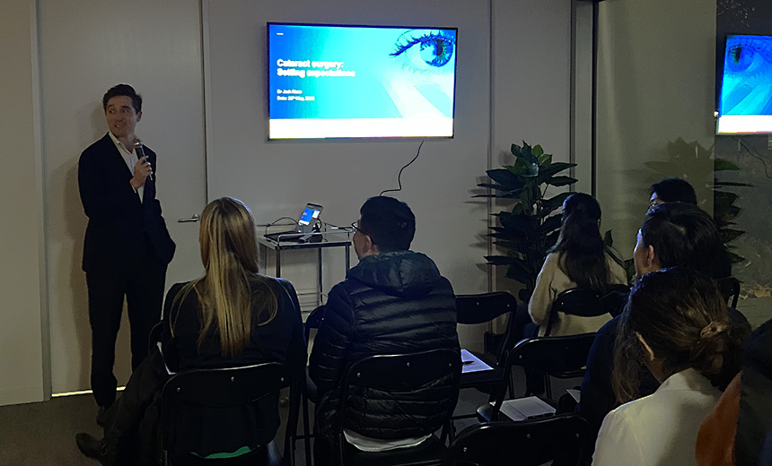 Dr Jack Kane speaks to a group of optometrists at Vision Eye Institute's Melbourne clinic. The projector screen shows a Powerpoint slide bearing the title of his talk, 'Cataract surgery: shifting expectations.'