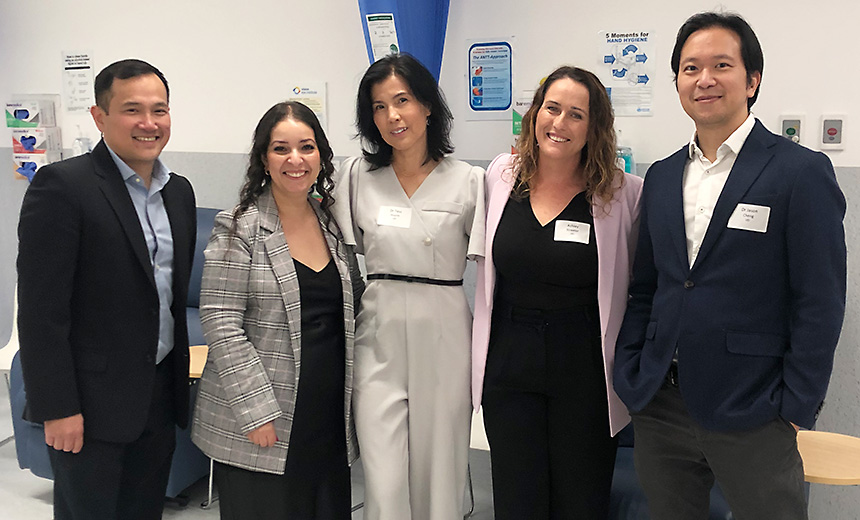 Practice manager at Vision Eye Institute Hurstville, Dr Tess Huynh and Dr Jason Cheng stand with two attendees at the Hurstville eye injection CPD evening. All five people are smiling at the camera, their arms around each other.