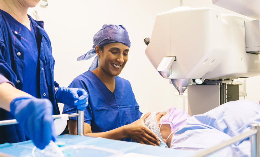 Dr Rushmia Karim in theatre (in scrubs) with a patient