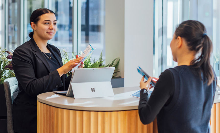 A medical receptionist goes through brochures with a client at a Vision Eye Institute clinic.