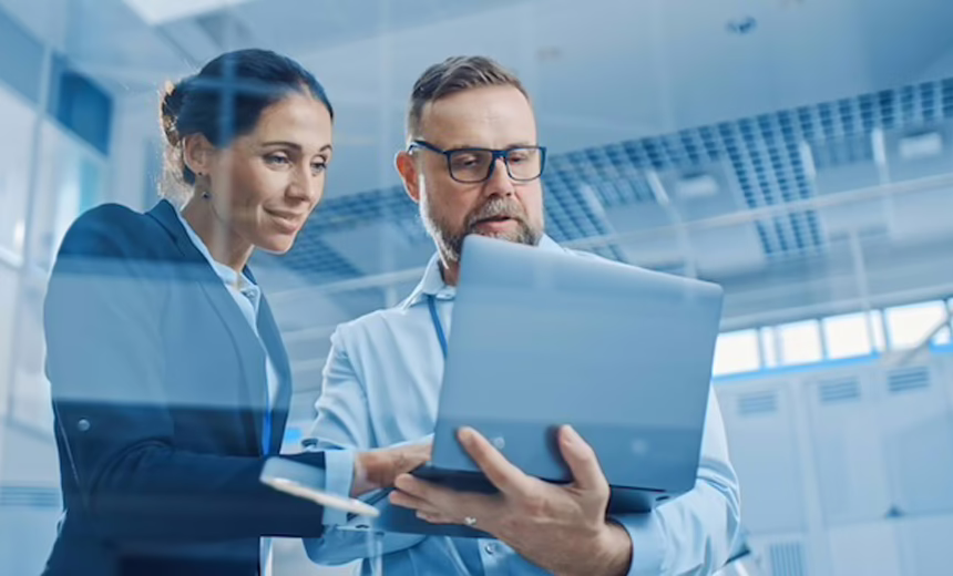 Two researchers looking over a laptop, examining it's contents.