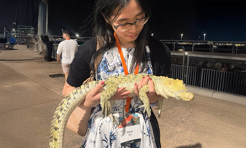 Orthoptist Opal Mei holding a baby crocodile at the 2025 Australasian Society of Cataract and Refractive Surgeons (AUSCRS) conference in Darwin, Australia.