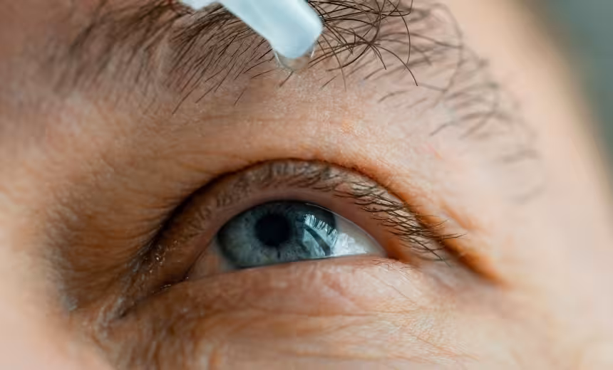 close up image of eye drops being put in to a blue eye for the topic of presbyopia eye drops