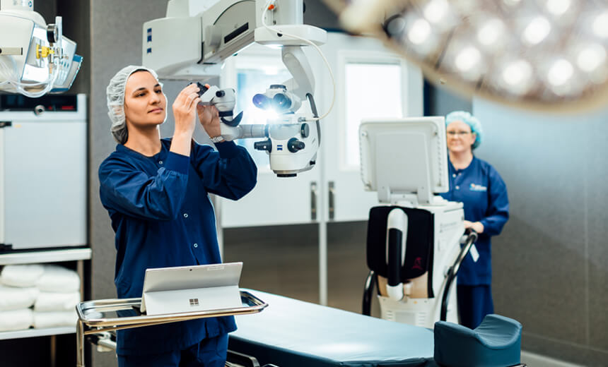 Day surgery nurse in scrubs adjusting theatre equipment