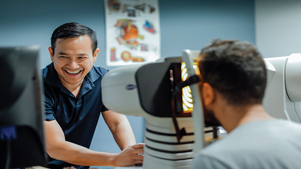 Male orthoptist smiling and talking to patient having eye test at Vision Eye Institute Bondi Junction