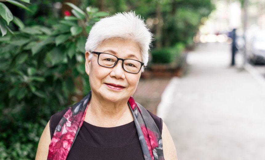 Smiling senior woman wearing glasses and standing outside
