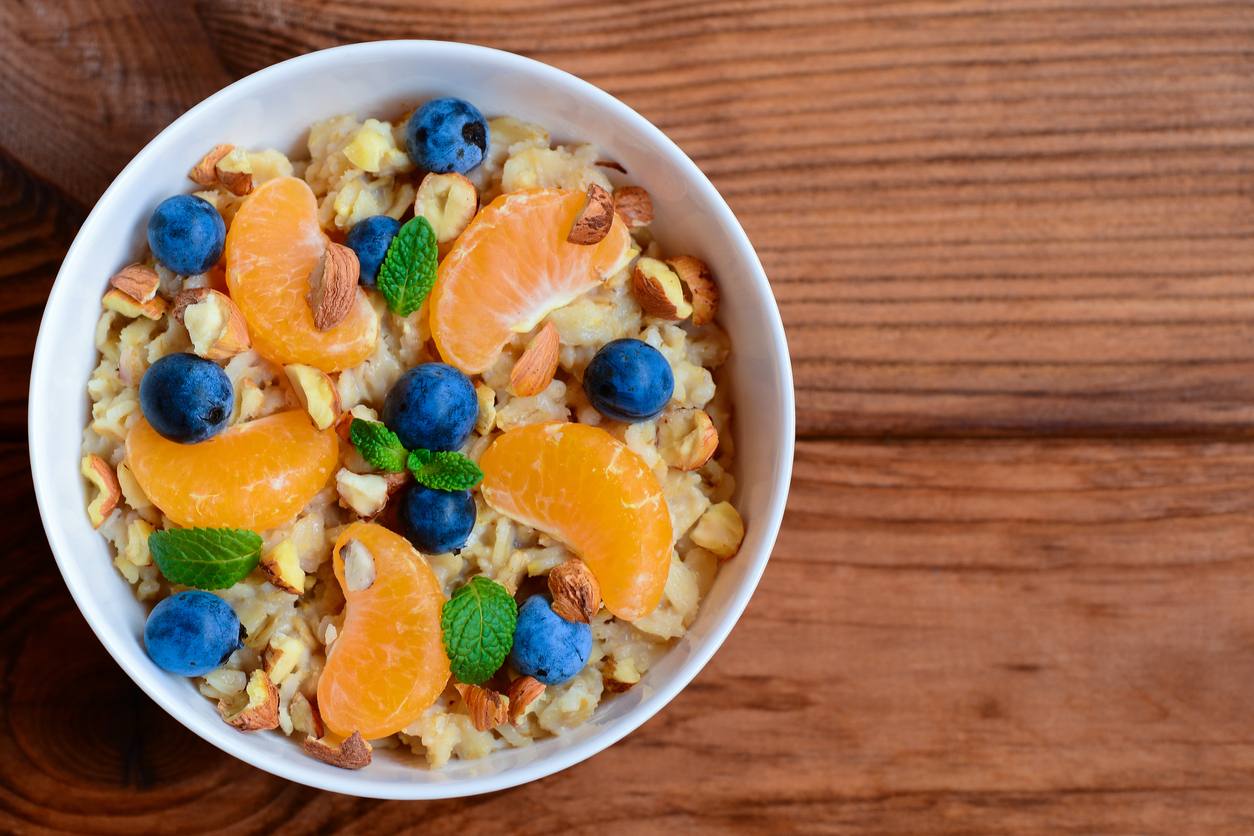 Porridge with fresh orange, berries and nuts ion a bowl.